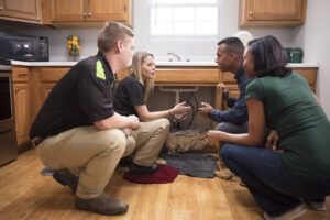 Servpro of Bend specialists consulting with homeowners about a water leak under a kitchen sink in Bend, OR