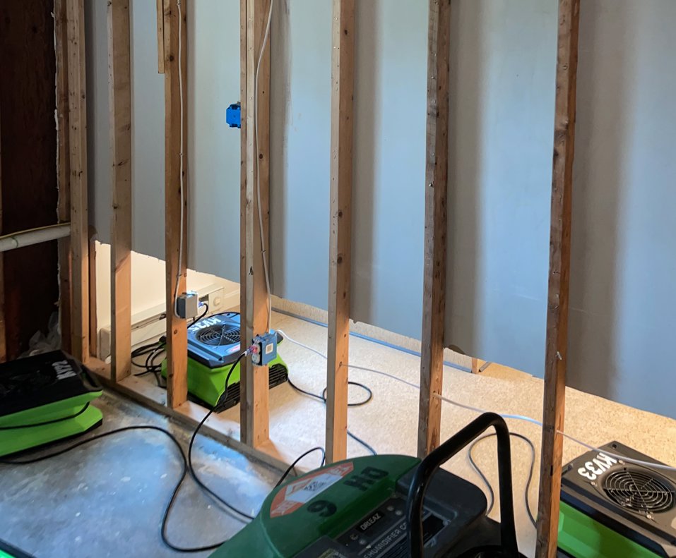 Servpro Team Paul water damage specialists using drying equipment in a room with exposed studs after remediation in Montpelier, VT.