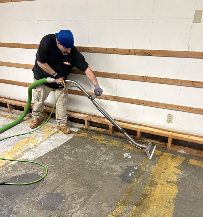 Servpro Team Paul water damage specialist performing water extraction from a concrete floor in Montpelier, VT.