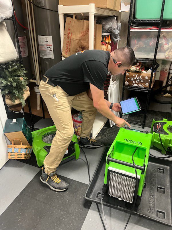 A Servpro technician checking drying equipment during a water damage restoration job in Athens, GA.