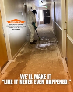 A Servpro of Rio Rancho / Sandoval County technician cleaning a water-damaged hallway floor in Rio Rancho, NM.
