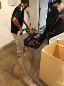 A SERVPRO technician extracting standing water from a basement floor in Annapolis/Severna Park, MD.