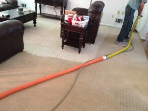 A SERVPRO technician extracting water from a wet carpet in a living room after water damage in Annapolis/Severna Park, MD.