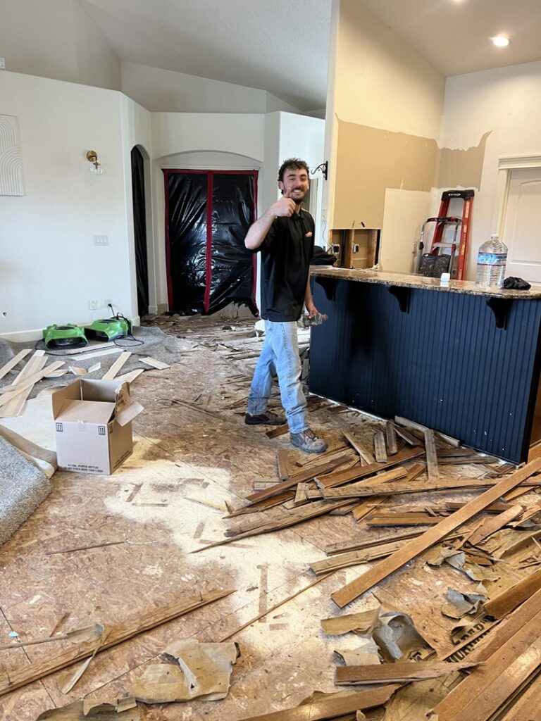 A SERVPRO technician giving a thumbs up amidst water damage demolition and drying equipment in Boise/Meridian, ID