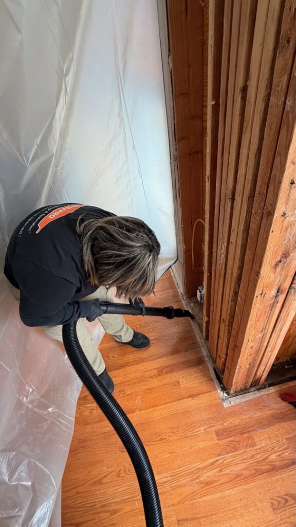 A Servpro worker vacuuming along a baseboard in a room for Servpro of SW Onondaga County in Syracuse, NY.