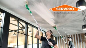 Servpro workers cleaning a ceiling with long-handled tools for Servpro of SW Onondaga County in Syracuse, NY.