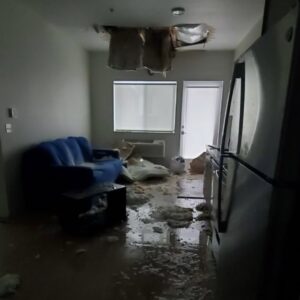 A severely water-damaged apartment with a collapsed ceiling and debris on the floor, requiring restoration by The Recover Tech Restoration in Vancouver, WA.