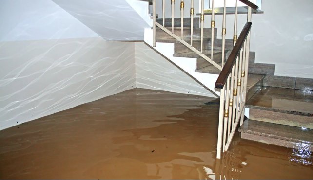 A severely flooded basement with brown water covering the floor, a common water damage scenario for SO-CO Water Damage in Pueblo, CO.