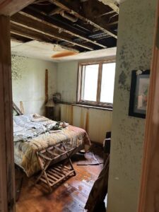 A severely water-damaged bedroom with mold on walls and wet floors, awaiting restoration by Restoration Alliance Services in Elk River, MN.