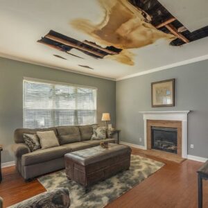A living room with severe water damage, showing a collapsed ceiling and exposed beams, handled by Carolina Pro Restoration LLC in Fort Mill, SC.
