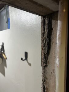 Severe water damage and peeling wood on a door frame, indicating a need for restoration services from Anytime Flood Restoration in Thornton, CO