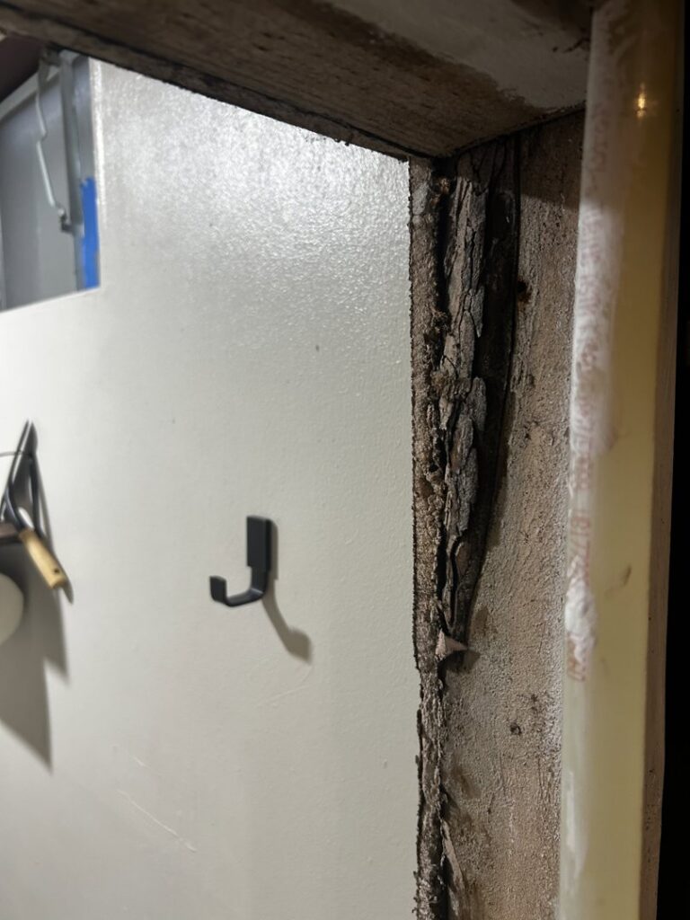 Severe water damage and peeling wood on a door frame, indicating a need for restoration services from Anytime Flood Restoration in Thornton, CO