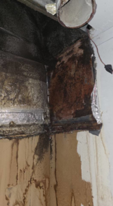 Severe water damage and mold growth in a corner with rusted components, indicating a major moisture issue, handled by ABS Restoration Services, Inc. in North Little Rock, AR