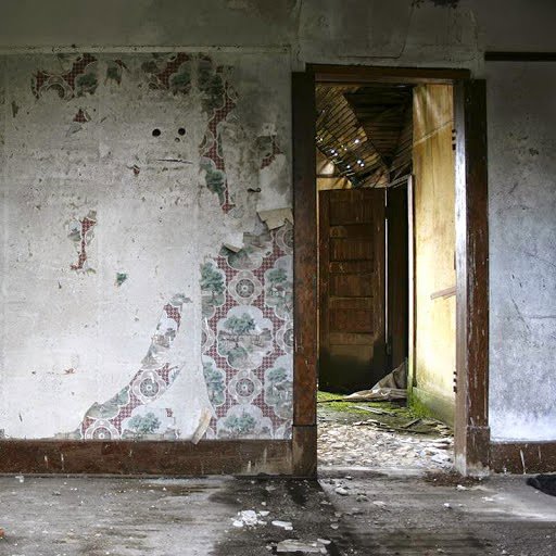A severely water-damaged room with peeling wallpaper and stained floors, indicating the need for restoration services from Rainbow Restoration of the Capital Region in Clifton Park, NY