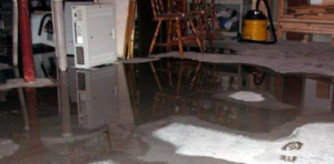 A severely flooded basement with standing water and reflections, showing extensive water damage in Philadelphia, PA.