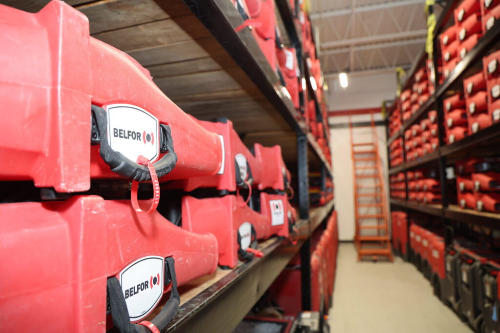 Shelves filled with red cases containing restoration equipment at Belfor Property Restoration in New Orleans, LA
