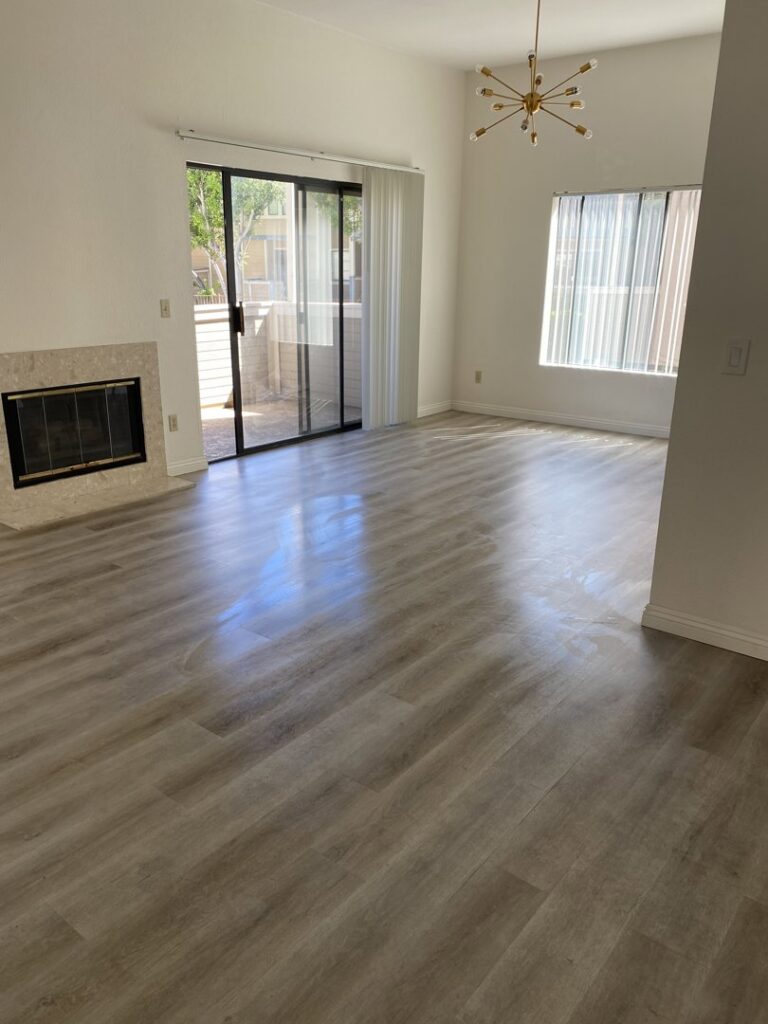 A living room with shiny, clean hardwood floors, showcasing professional cleaning by Maid 2 Clean San Diego, CA