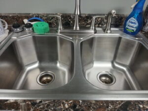 A shiny, professionally cleaned kitchen sink by Mama's Touch Cleaning Service LLC, ready for use in Evansville, IN.