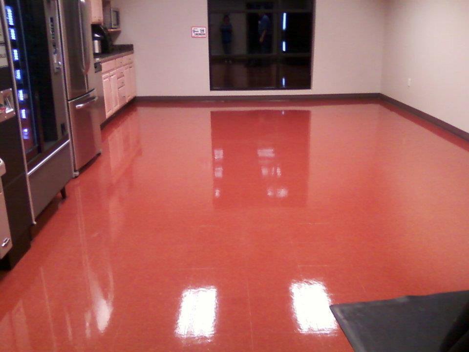 A sparkling clean, highly polished red floor in a large room, showcasing results from C&K Cleaning Services, LLC in Cedar Rapids, IA