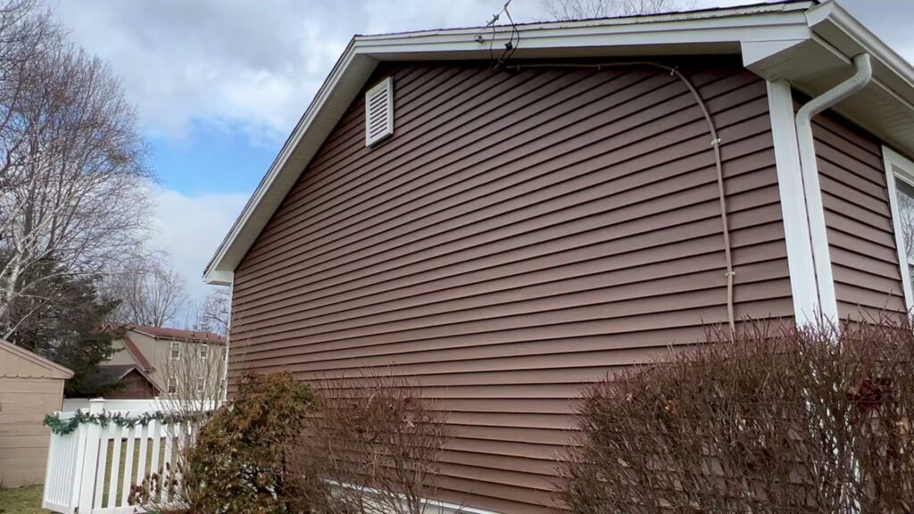 The side of a residential home featuring new brown horizontal siding installed by DL Roofing and Siding in New Haven, CT