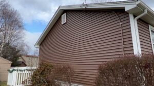 The side of a residential home featuring new brown horizontal siding installed by DL Roofing and Siding in New Haven, CT