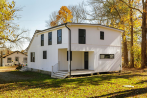 Side view of a modern white house with vertical siding installed by Atlantic Roofing and Siding in East Hartford, CT.