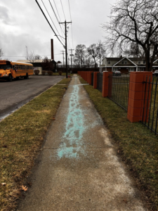 A sidewalk treated with ice melt for safety by 10.7 Property Solutions LLC in South Bend, IN