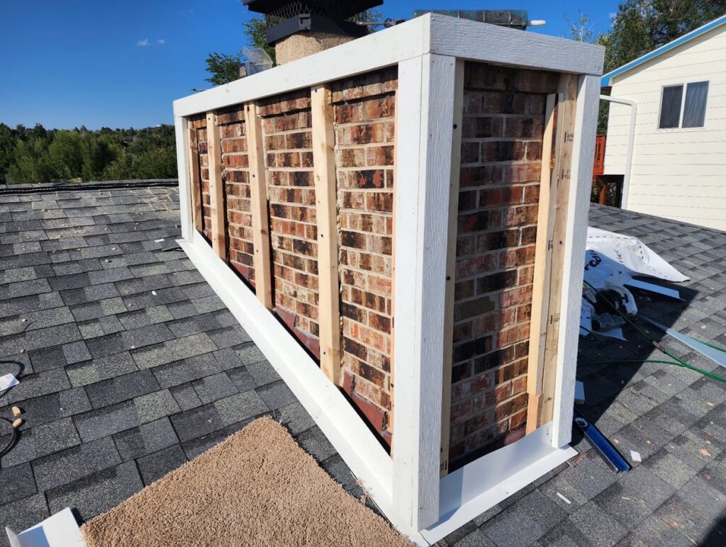 Wood framing on a brick chimney, preparing for new siding by EZ General Construction in Colorado Springs, CO.