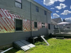 Siding installation in progress on a house, showing insulation board, by Coastal Construction Group LLC in Cheshire, CT.