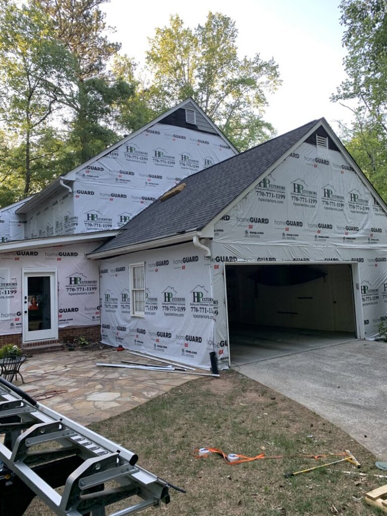 A house undergoing siding installation, wrapped in HomeGuard, by HP Exteriors in Woodstock, GA