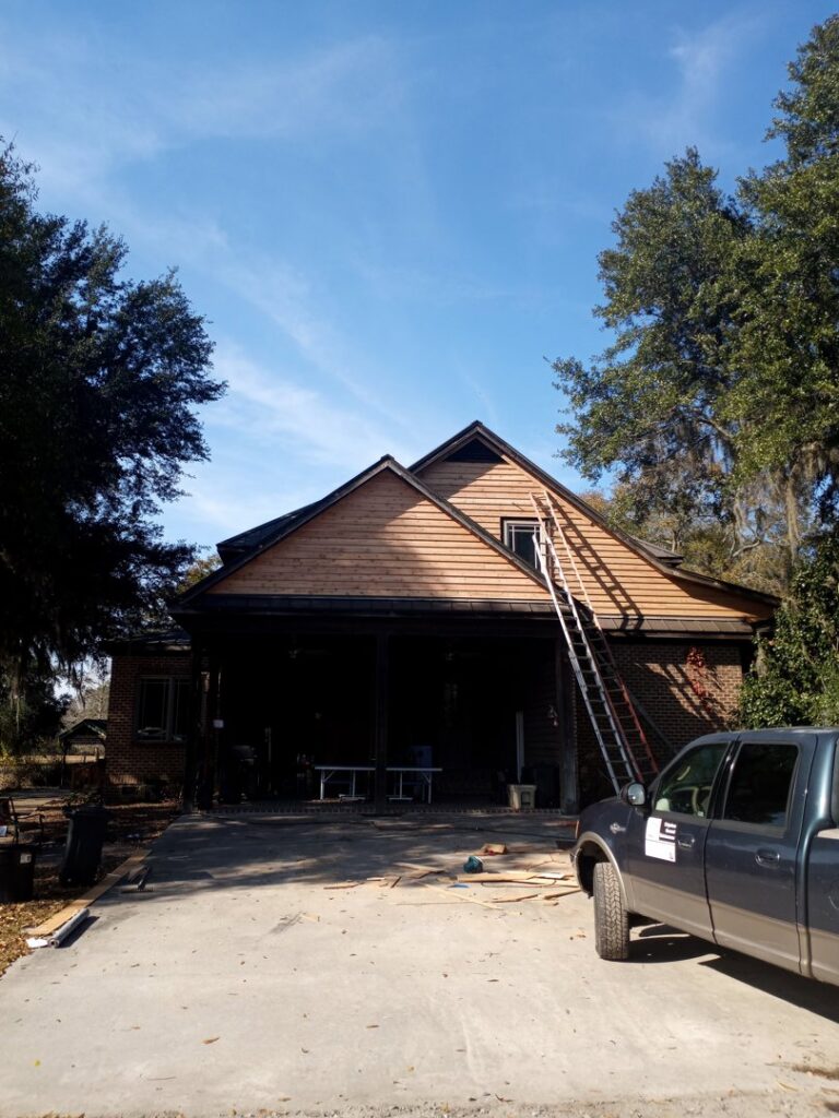 Siding installation in progress on a house with ladders by Action Roofing and Siding Co in South Saint Paul, MN