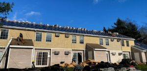 Siding installation in progress on a multi-unit residential building by Pride Exteriors in North Attleborough, MA.