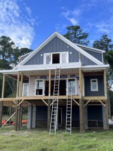 New construction home with dark blue siding being installed by Cordell Exteriors Inc in Chesapeake, VA