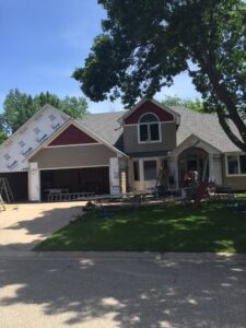 Siding installation with Tyvek house wrap and new beige and red siding by Capital Siding, Windows & Roofing, Woodbury, MN.