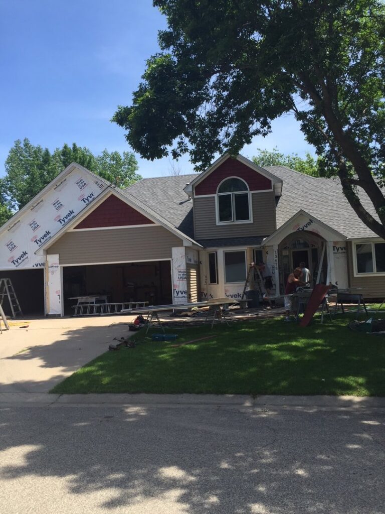 Siding installation with Tyvek house wrap and new beige and red siding by Capital Siding, Windows & Roofing, Woodbury, MN.