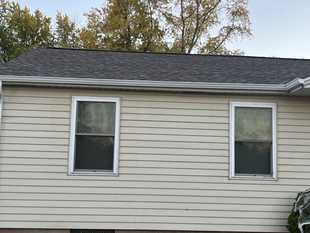 Siding installation in progress on a house, showing blue siding and Norandex house wrap by Wisconsin Exteriors in Kaukauna, WI.