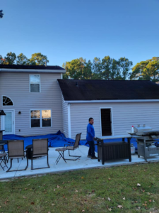 A worker near a house with new siding installed by Action Roofing and Siding Co in South Saint Paul, MN