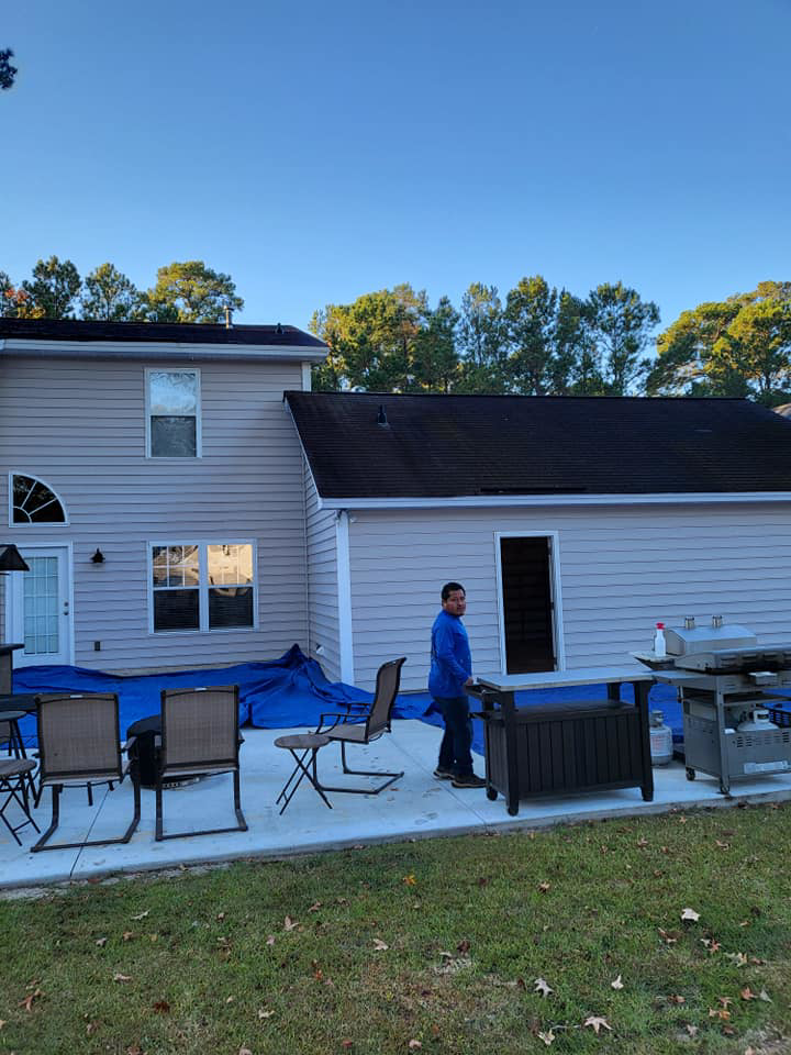 A worker near a house with new siding installed by Action Roofing and Siding Co in South Saint Paul, MN