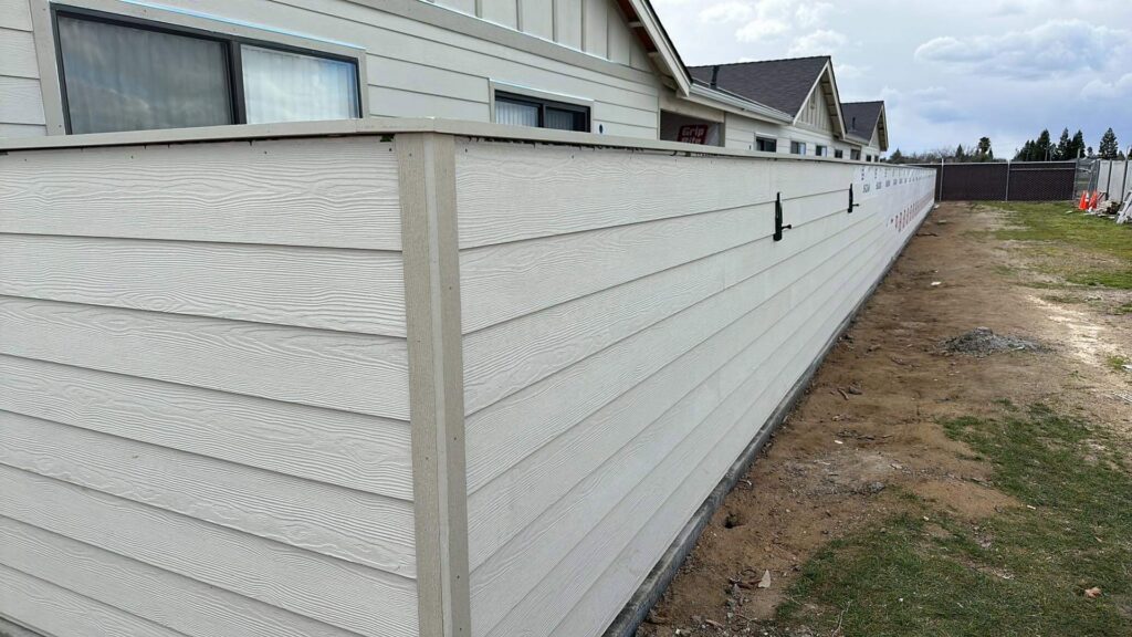 A newly installed privacy wall made of horizontal siding panels by Bushco Contracting LLC in Fresno, CA.