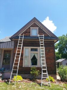 Siding removal and preparation work on an old house, with ladders, by Freeman Exteriors in Danville, IL.