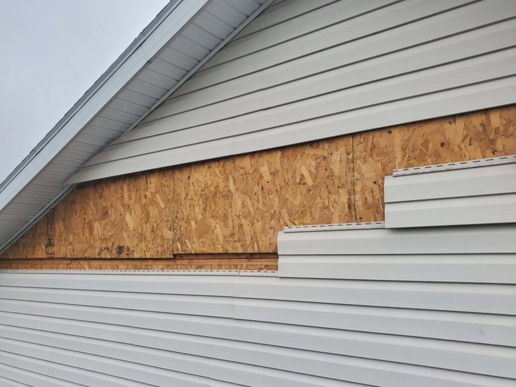 House siding removed, exposing underlying sheathing, a common step in water damage repair by Barbera Home Improvement in Parma, OH.