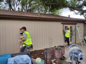 A contractor working on siding repair and installation on a residential home by Home Quality Solutions,LLC in Old Orchard Beach, ME