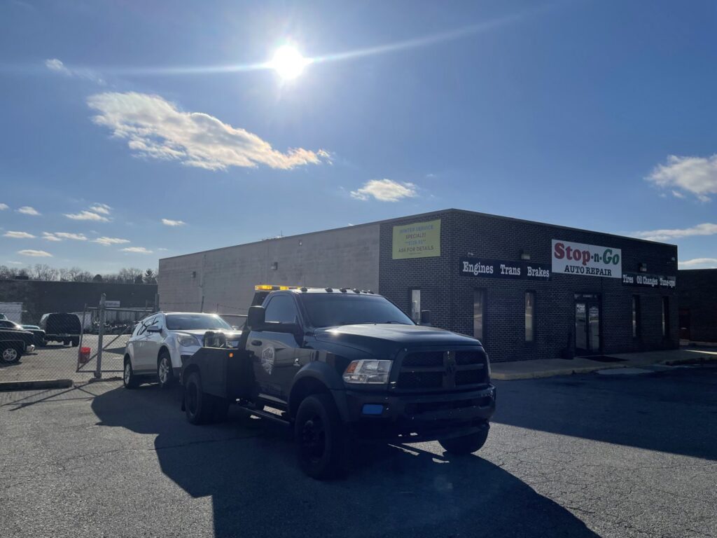A silver car being towed by a wheel-lift tow truck from Nacho Transports llc in Middletown, DE.
