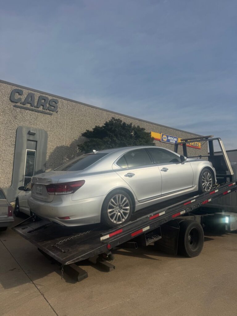 A silver Lexus sedan being loaded onto a flatbed tow truck by Towing Near Me 247 LLC in Irving, TX.