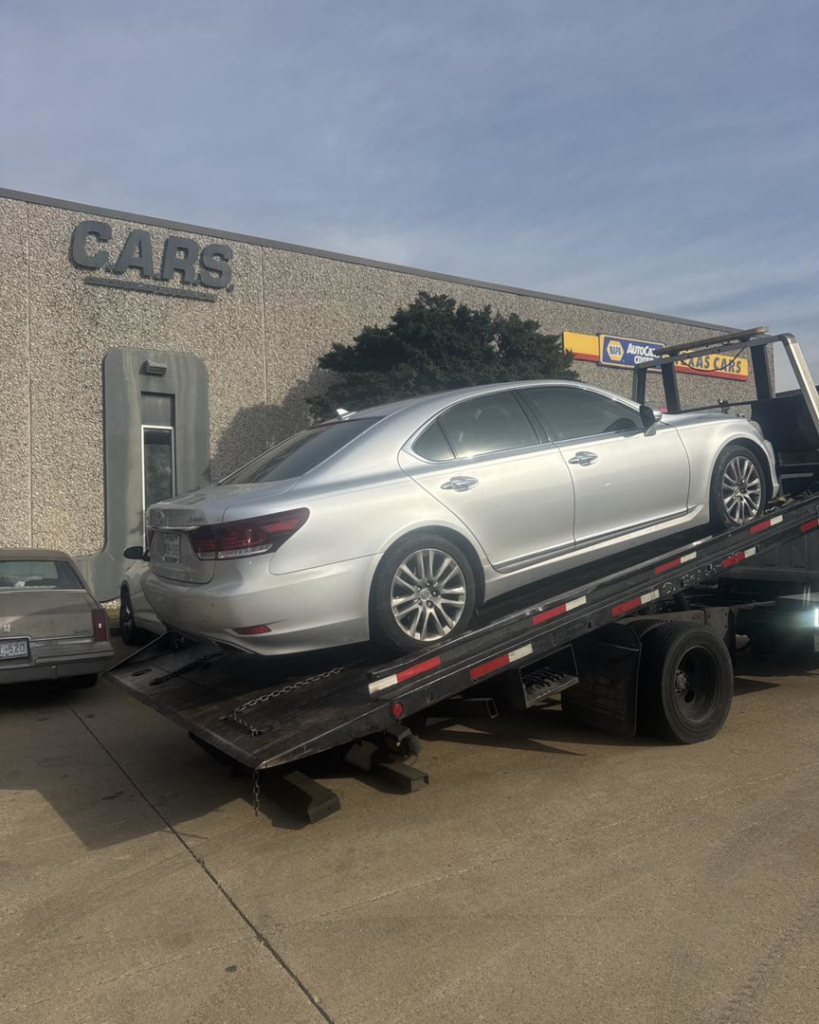 A silver sedan loaded onto a flatbed tow truck by Towing Near Me 247 LLC Dallas in Dallas, TX.