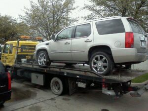 A silver SUV being transported on a Tow Jam flatbed tow truck by Tow Jam in Dallas, TX.