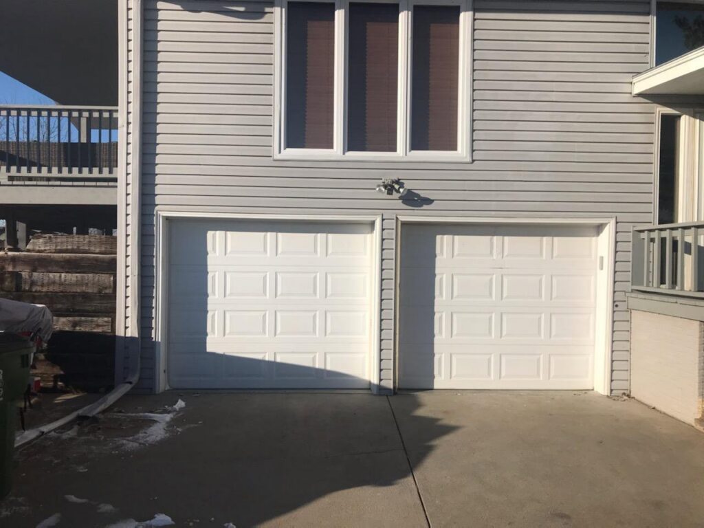 A single white garage door installed on a residential home by JLM Garage Doors Omaha in Papillion, NE.