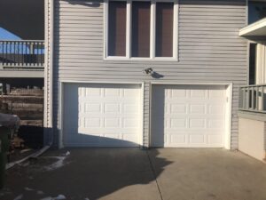 A single white garage door installed on a residential home by JLM Garage Doors Omaha in Papillion, NE.