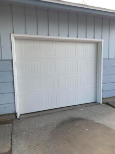 A newly installed single white panel garage door by Next Level Garage Doors in Locust Grove, GA.
