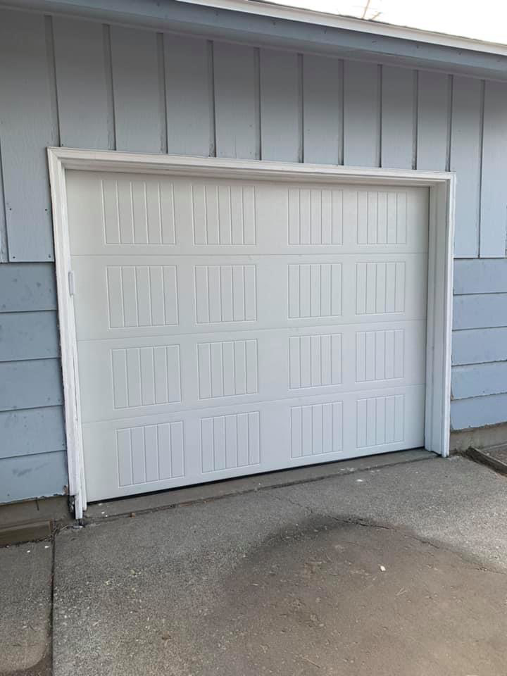 A newly installed single white panel garage door by Next Level Garage Doors in Locust Grove, GA.